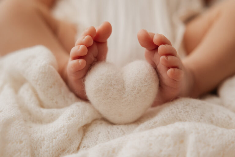 Gros plan sur les pieds d’un bébé lors d’une séance photo naissance près de Rambouillet.
