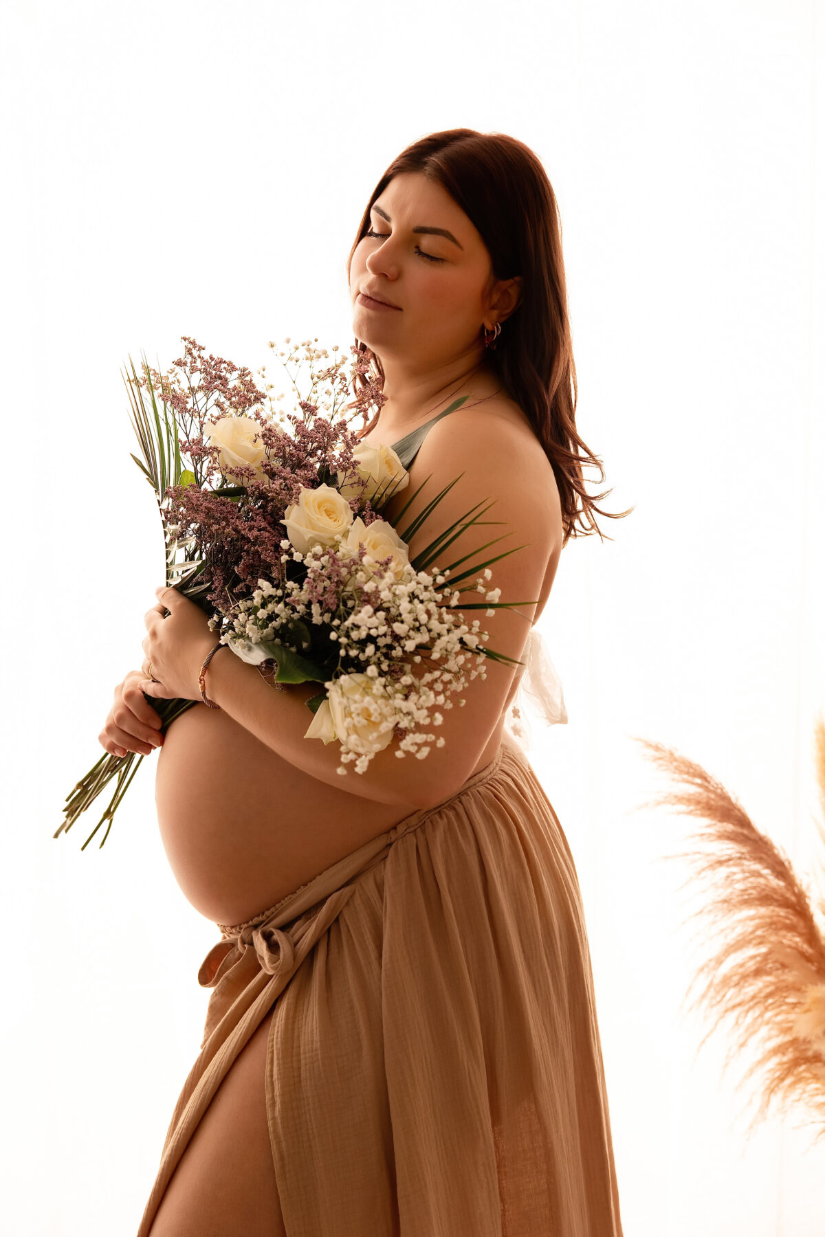 Portrait d’une femme enceinte mettant en valeur sa silhouette au studio.