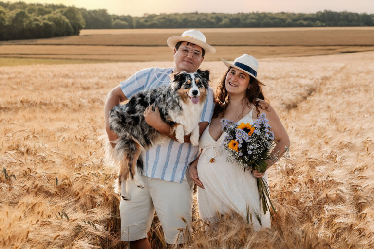 Séance photo grossesse en extérieur, couple attendant un bébé avec son chien.
