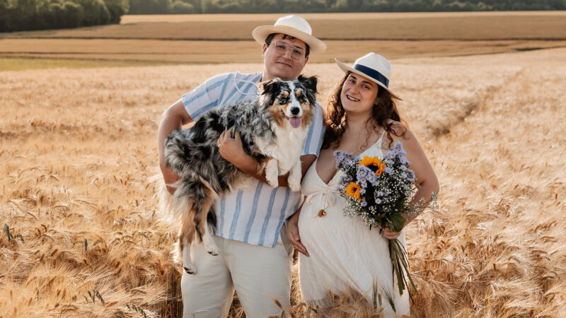 Séance photo grossesse en extérieur, couple attendant un bébé avec son chien.