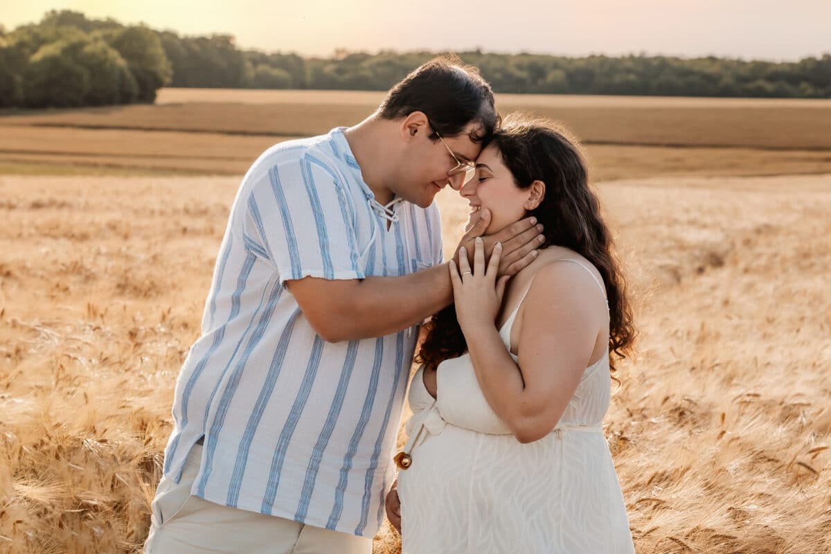 Couple attendant un bébé lors d’une séance photo grossesse en extérieur dans les champs, près de Chartres.