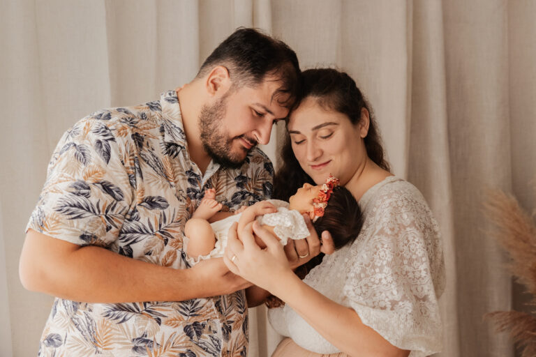Jeunes parents tenant leur nouveau-né dans les bras lors d’une séance photo naissance près d’Ablis.