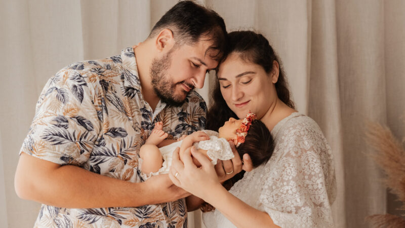 Jeunes parents tenant leur nouveau-né dans les bras lors d’une séance photo naissance près d’Ablis.