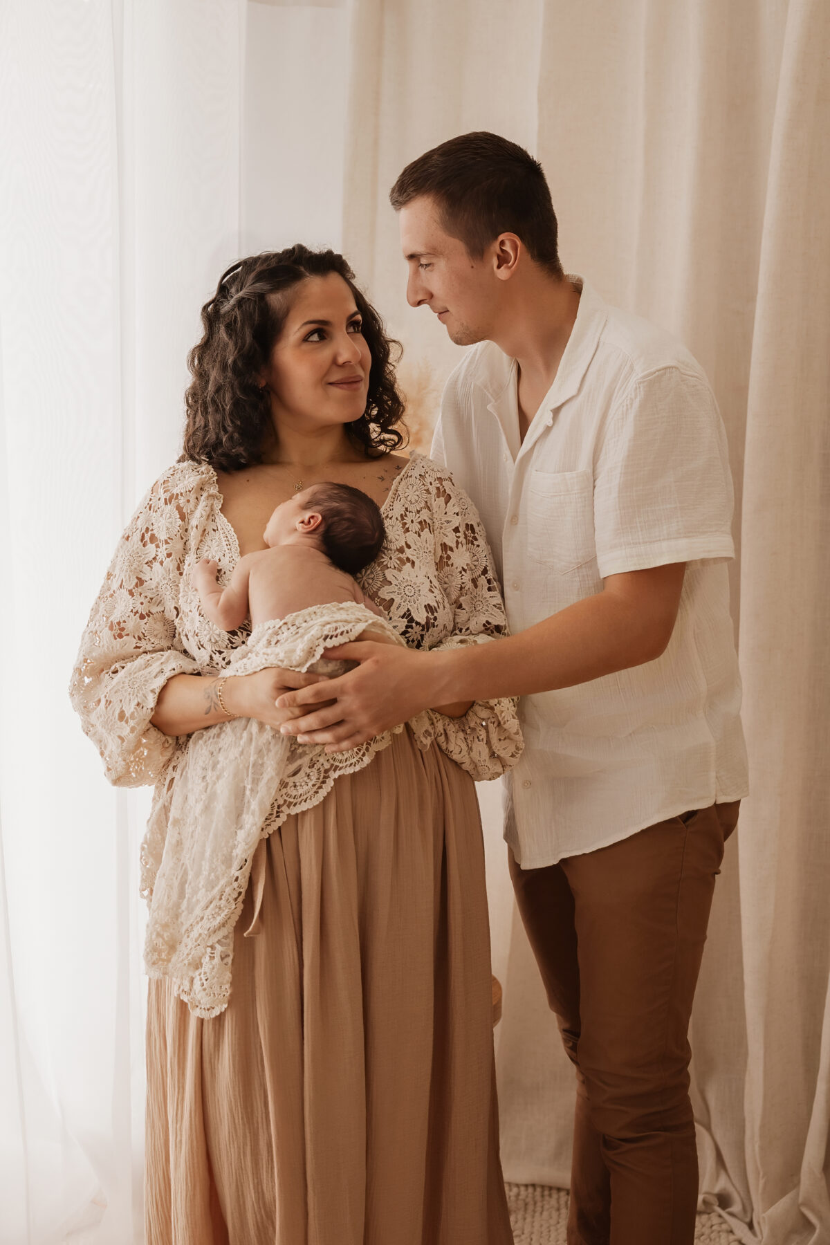 Séance photo naissance près de Chartres, parents tenant leur nouveau-né dans les bras.